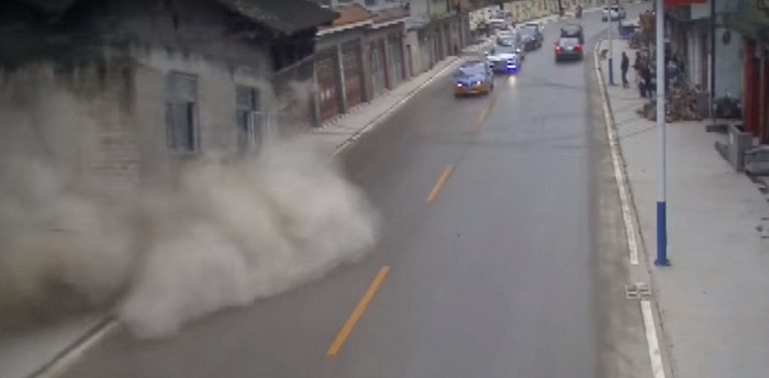 Two houses collapse on busy road after landslide in China - VIDEO